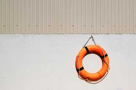 Orange lifebuoy hanging on a wall.